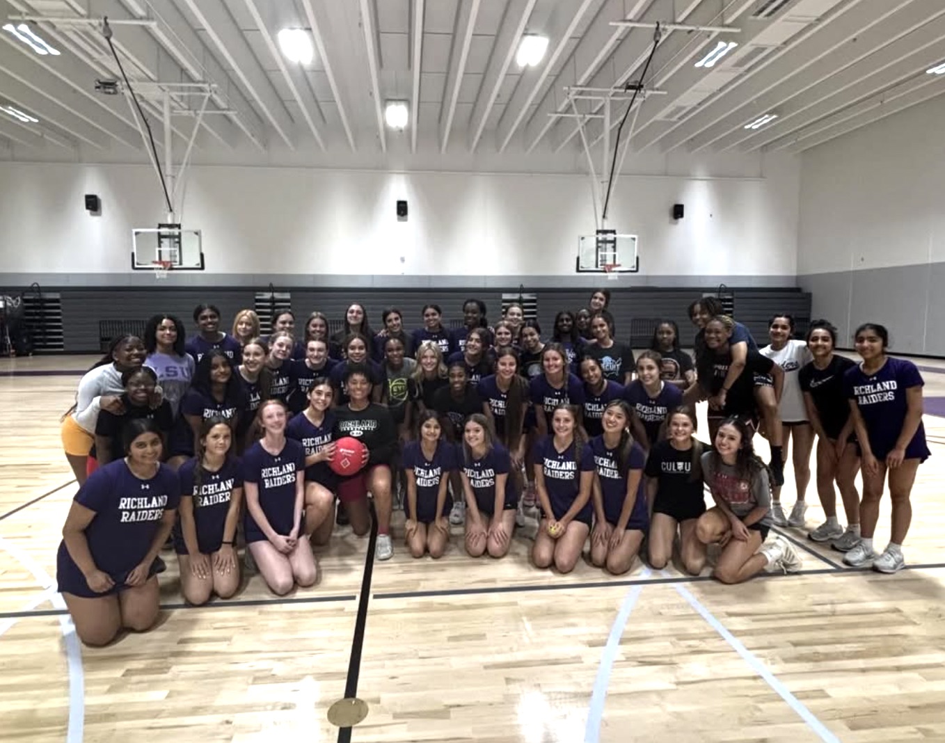 The Richland Raiders volleyball team together in the gym